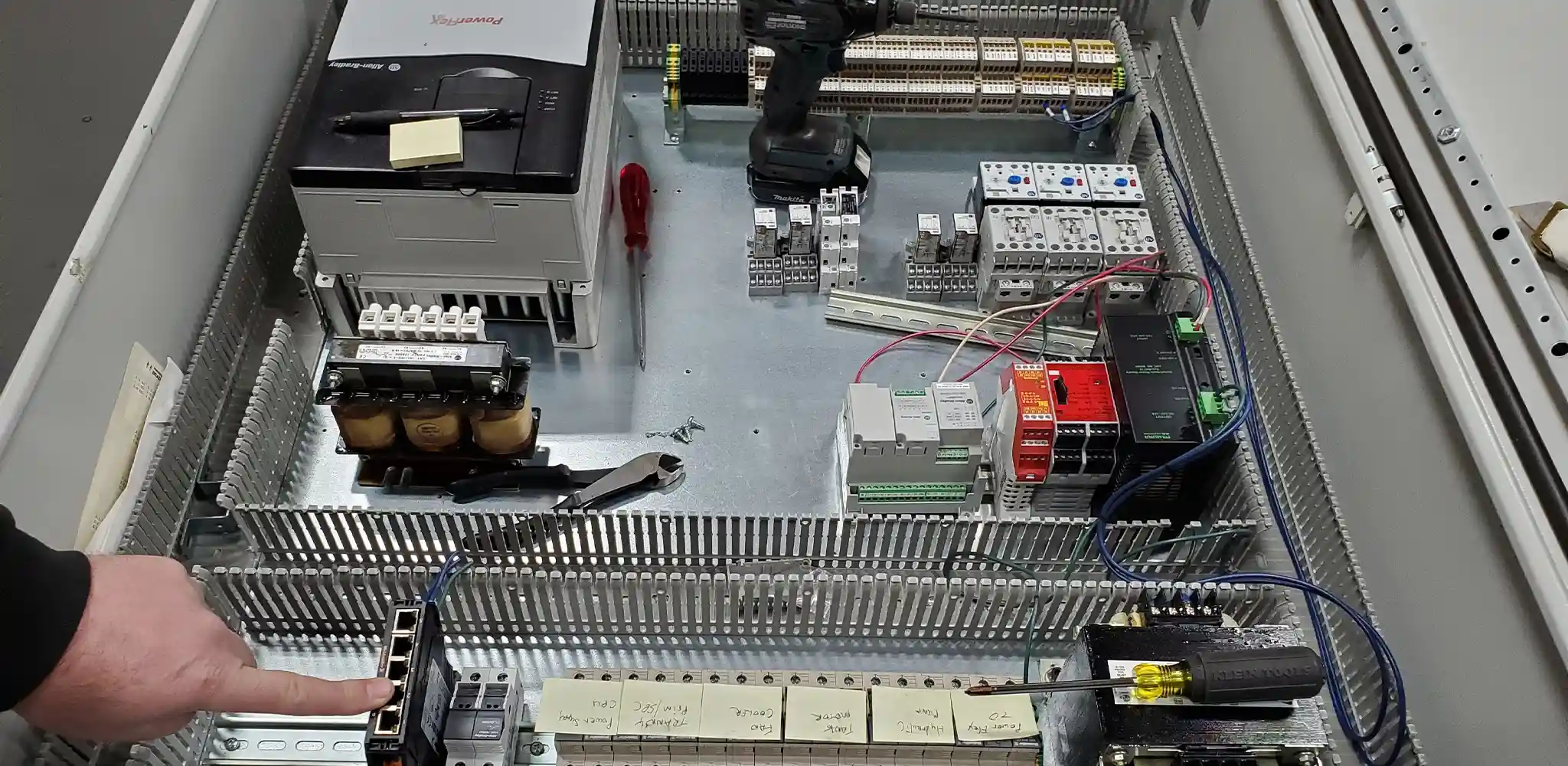 Technician working inside an industrial control panel